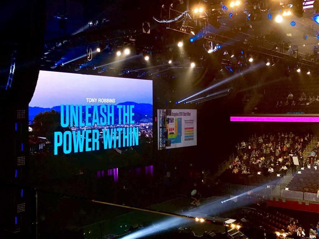 Photo of stage and screens at Tony Robbins event
